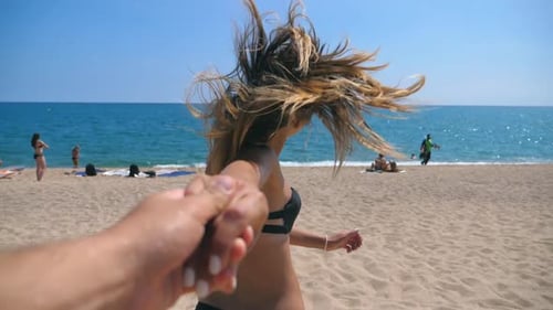 Follow Me Shot of Young Woman Pull Her Boyfriend to the Sea Shore