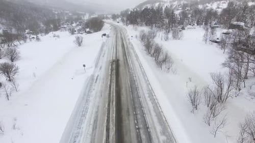 Aerial View of a Winter Road in a Snowy Day.
