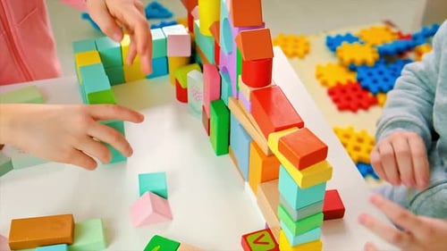 Children Play Building Blocks Together Indoors