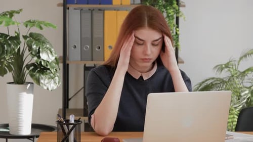 Woman with Headache at Her Office Desk