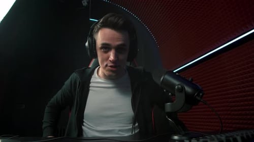 Young Man Wearing Headphones in Gaming Room