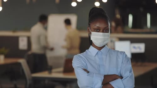 Professional Woman Wearing Mask in Modern Workplace