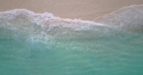 Beautiful fly over abstract shot of a white sandy paradise beach and aqua turquoise water background
