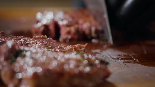 Juicy Steak Being Sliced on a Cutting Board
