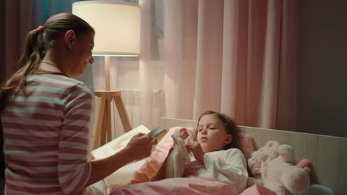 Mother Reads Bedtime Story to Young Daughter