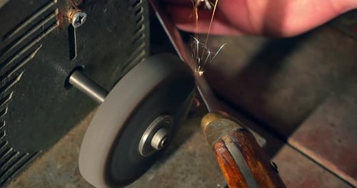 Sharpening the Old Knife on the Grinding Machine. Close-up