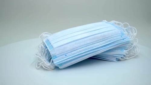Stack of Blue Disposable Surgical Face Masks Close-Up