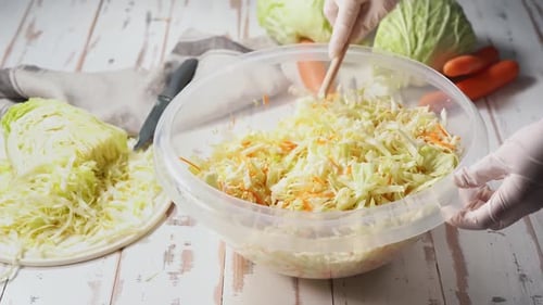 Female Hands in Gloves Mixing Chopped Cabbage in a Big Bowl for Fermentation
