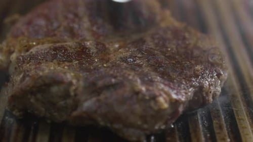 Taking Juicy Steak from Grill