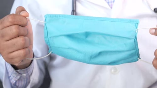 Close Up of Doctor Hand Holding Surgical Face Mask