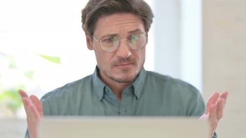 Man Expresses Shock while Working on Laptop