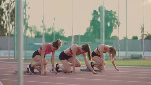 Athletes Prepare to Sprint on Running Track