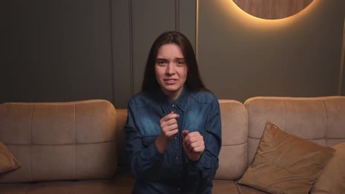 Anxious Woman Sitting on Couch Looking Stressed