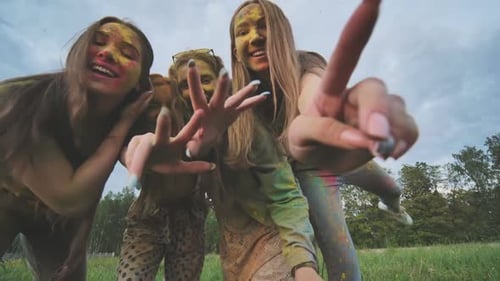 Cheerful Girls are Posing Smeared in Multicolored Powder