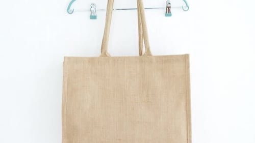 Bolso y percha colgados en la pared blanca