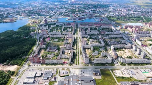 Drone suburban panorama. River, park and residential buildings under cloudy sky