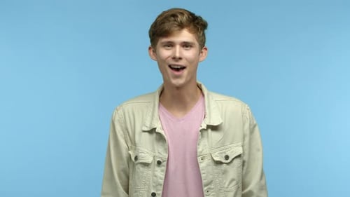 Young Man Talking and Gesturing on Blue Background