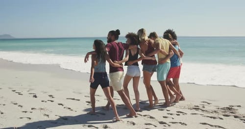 Group of Friends Walking Arm-in-Arm on Beach