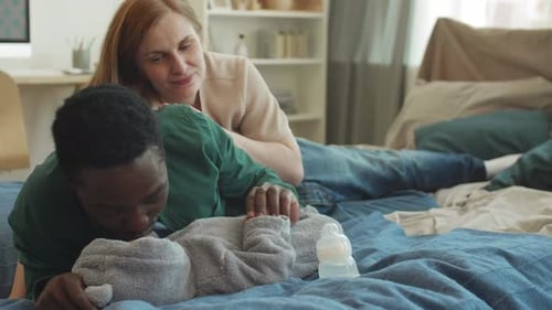 Loving Couple Admiring Newborn Baby at Home