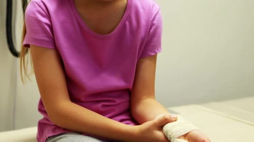 Young Girl with Bandaged Wrist in Hospital