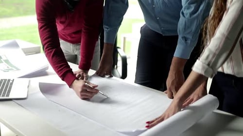 Team Reviews Architecture Plans on White Table