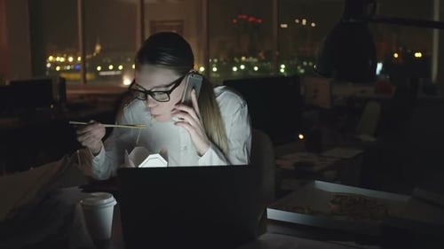 Woman Eating and Talking on Phone at Night
