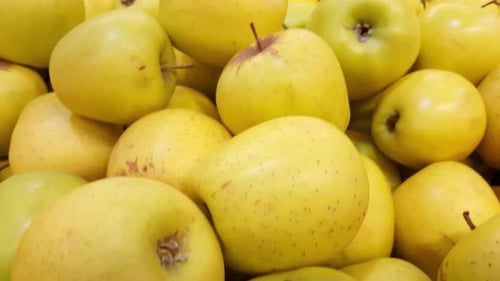 Montón de manzanas rojas, amarillas y verdes en un mercado, movimiento panorámico