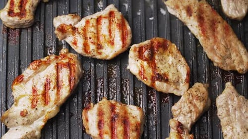 Process of cooking roast meat on a metal electric grill. Delicious prepared pork. Close-up