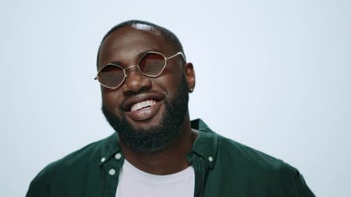 Closeup Happy African Man Smiling in Sunglasses on Camera in Grey Background