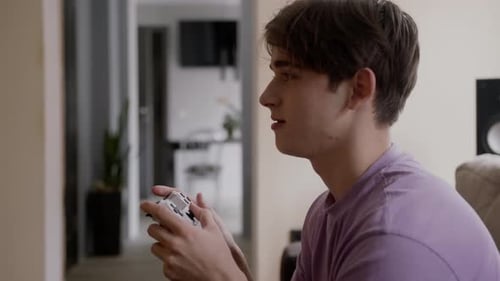 Young Adult Gaming at Home with Controller