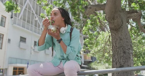 Young Adult Eating Salad Outdoors in the City