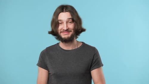 Portrait of Attractive Bearded Guy in Casual Grinning and Showing Fingers on Camera Meaning Hey you