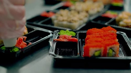 Cook Serves Japanese Rolls with Caviar of Flying Fish Adds Wasabi