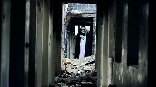 Scary Figure in Robe Holding Plank in Damaged Building