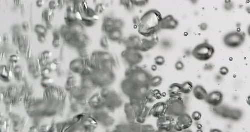 Flüssigkeit wird in Wasser gegossen und verursacht aufsteigende Blasen