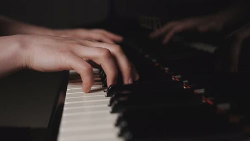 Hands Play Keys on Black Piano Instrument