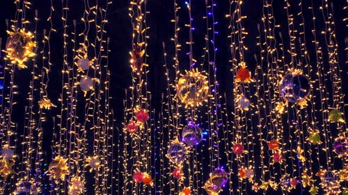 Hermosas y coloridas decoraciones navideñas se mecen con el viento contra el cielo nocturno