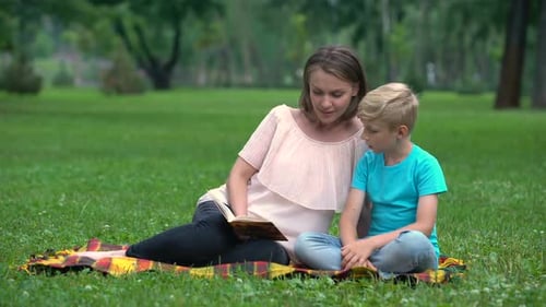 Mother and Son Doing Homework Together in Park, Child Education, Parenthood