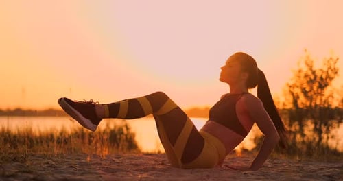 Femme de remise en forme faisant des craquements à la plage