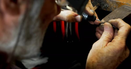 Senior goldsmith manufacturing bangle in workshop 4k
