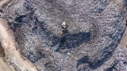 Bulldozer Working at a Large Garbage Landfill Site