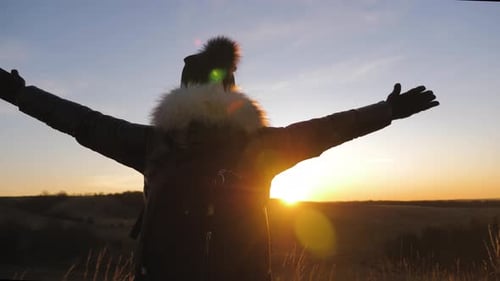 Silhouette Hiker Celebrates Scenic Sunset in Rural Landscape