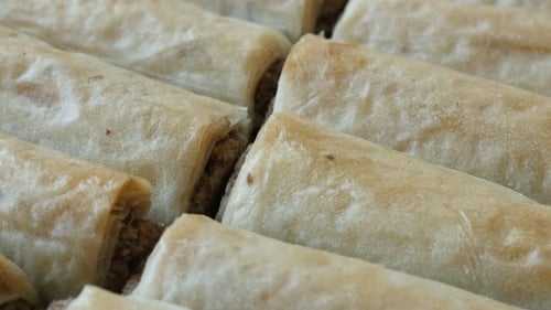 Poêle lentement sur de la pâte à filo orientale, des rouleaux de baklawa sucrés fourrés aux noix 4K 2160p 30fps UHD footage - Pa