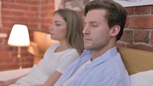 Portrait of Young Couple Looking in Camera From Bed