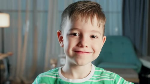 Porträt Lustiger kleiner Junge lächelndes Kind schaut in die Kamera sitzt auf der Couch zu Hause Cute Kid