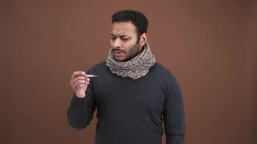 Adult Man Checks Fever with Thermometer