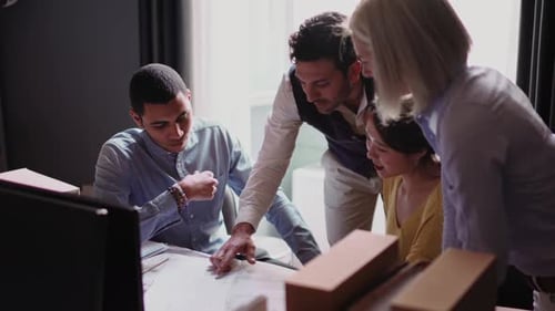Group of people looking at blueprint in the office