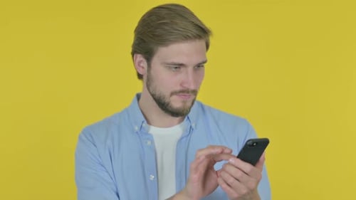 Man Uses Smartphone on Bright Yellow Background