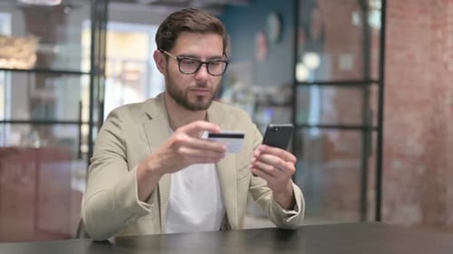 Young Man Making Online Payment on Smartphone