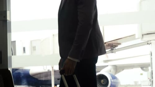 Man Pulls Suitcase Through Airport Terminal